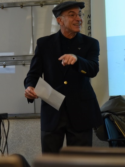 Male professor, Stephen Gambescia, PhD, wearing a sport coat and hat teaching a class.
